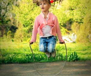 Beautiful,Little,6,Years,Old,Girl,Jumping,Over,The,Rope Beautiful little 6 years old girl jumping over the rope in the park on sunny summer day